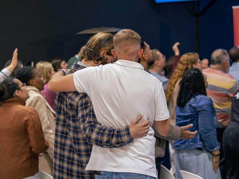 Friends embracing during worship